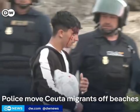 Spansk politi fjerner en blodig migrant fra Ceuta. Foto fra Deutsche Welle video.